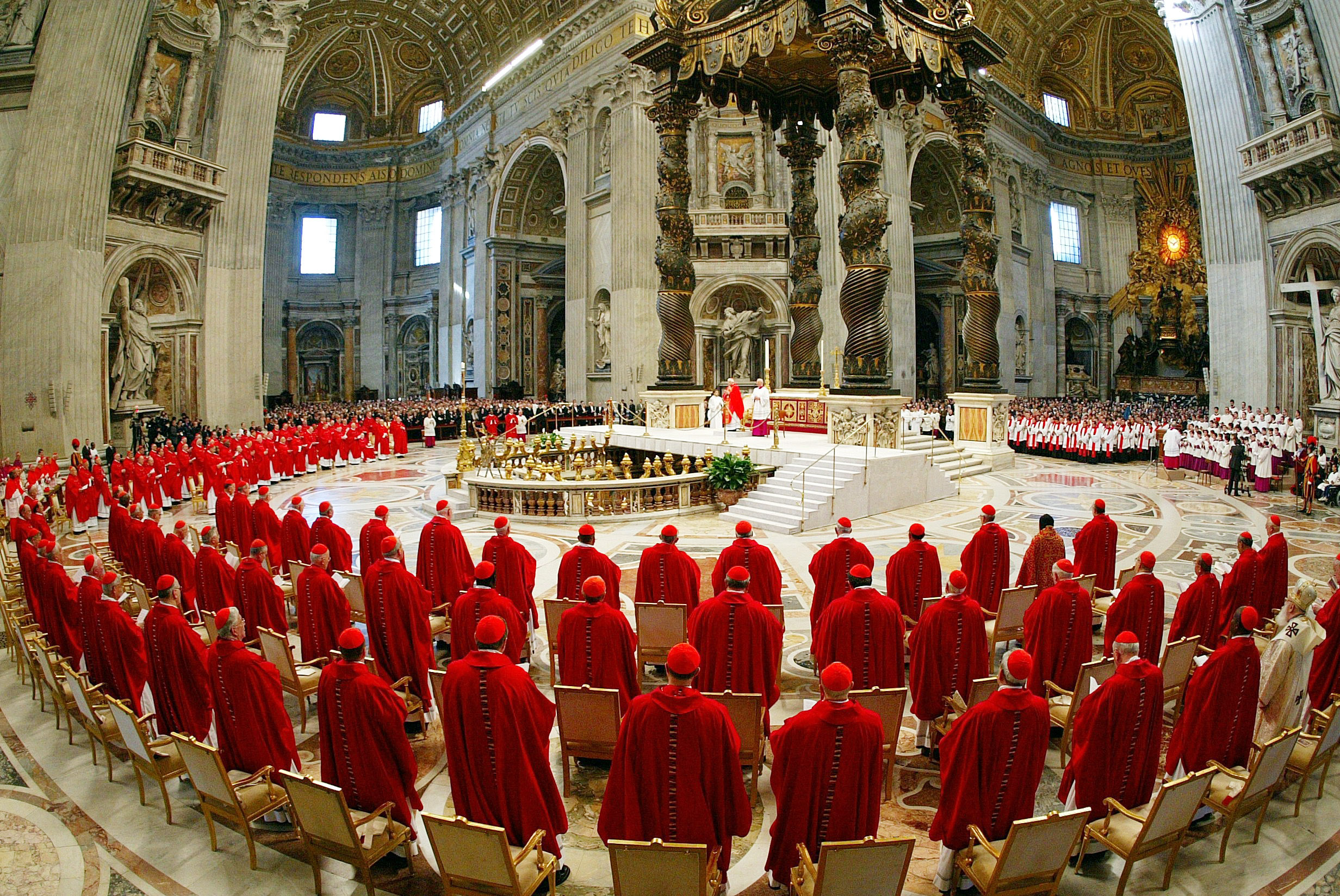 I cardinali vestiti con i paramenti rossi, in piedi davanti l'altare principale della Basilica di San Pietro per partecipare alla messa solenne ''pro eligendo pontifice'', che apre i riti del conclave per l'elezione del successore di Giovanni Paolo II il 18 aprile 2005.   ANSA