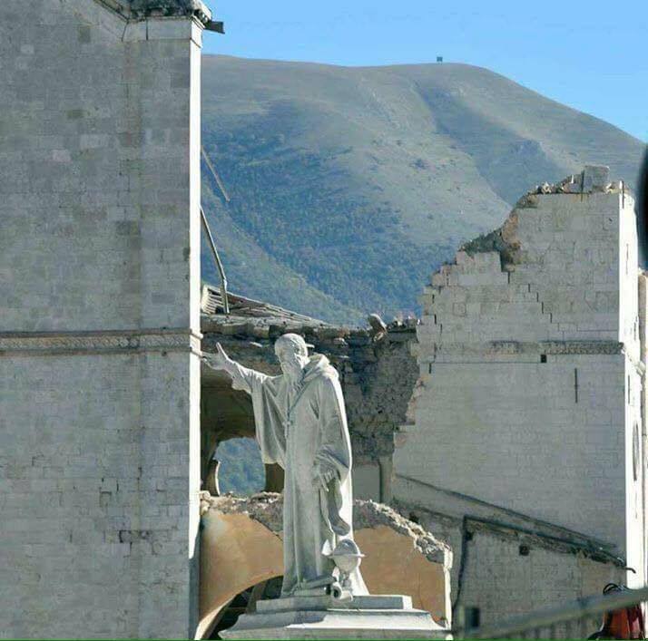 La statua di San Benedetto tra le rovine del terremoto del 30 ottobre 2016 a Norcia (Perugia)